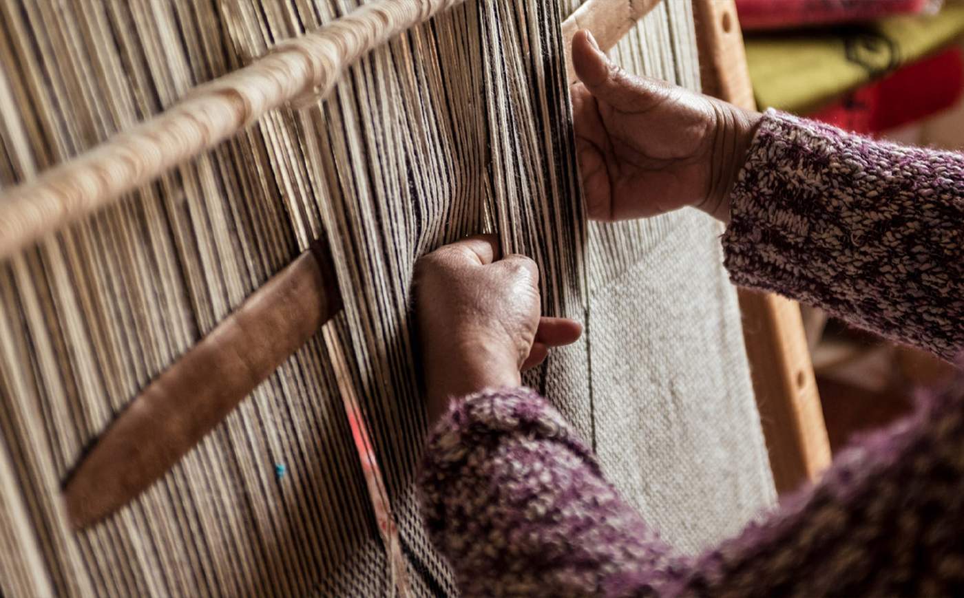 A Mapuche weaver's hands at work on a traditional upright loom