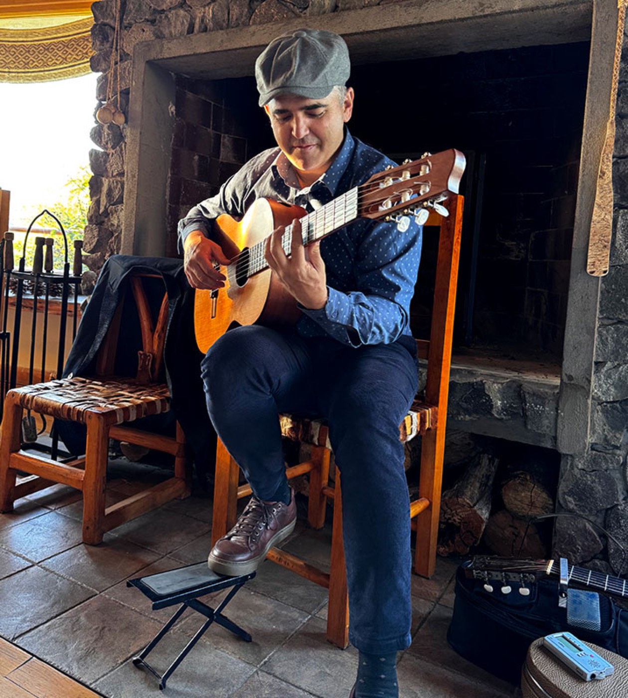A guitarist playing beside the lodge's stone fireplace